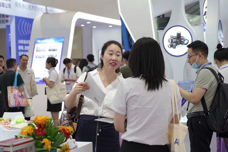 球迷体育
工作人员与现场参观者探讨产品图2